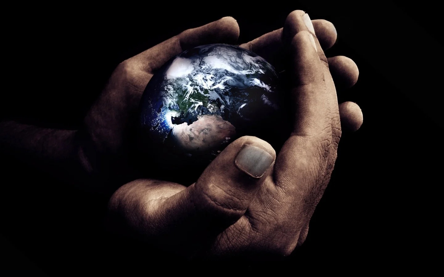 A hand holding a small globe